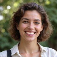 Portrait of a friendly, diverse team member smiling, in a bright, natural setting.